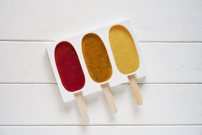 Three different fruit smoothie popsicles in reusable silicone ice pop mold or form  ice lollies