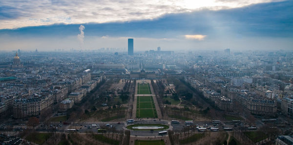 Aerial view of cityscape against cloudy sky