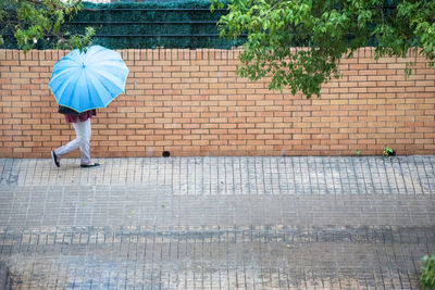 Rear view of woman walking on footpath