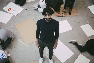 High angle portrait of young man standing on tiled floor