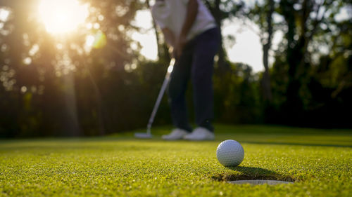 Low section of man playing golf on field