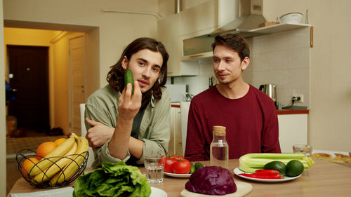 Portrait of young man preparing food in kitchen at home