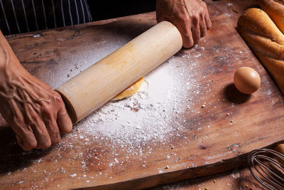 Cropped hands of man preparing food at table