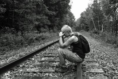 Woman sitting on railroad track