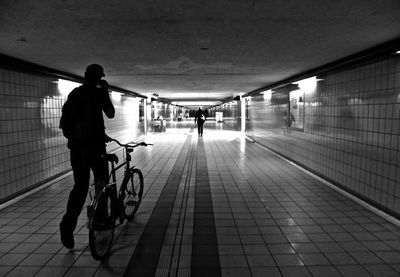 Man with bicycle walking in basement
