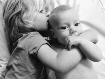 Close-up of siblings in bed