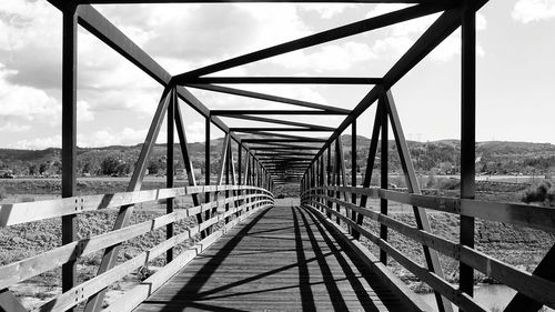 Bridge over river against cloudy sky