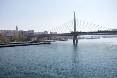 Bridge over river against sky in city