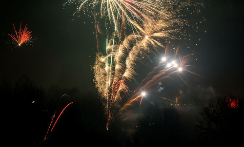 Low angle view of firework display at night