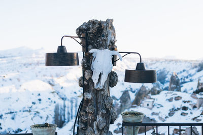 Close-up of wooden post against snow covered mountain