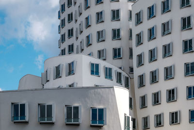 Exterior aluminium windows align on white curvature facade at madiahafen.