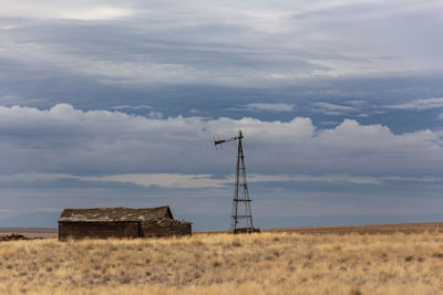 Windmill on field against sky