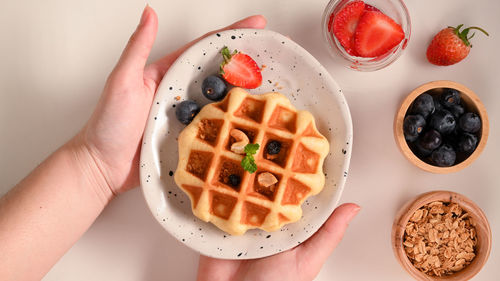 Cropped hand of woman holding food