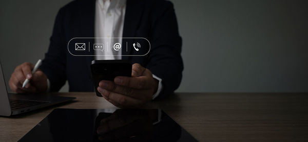 Midsection of businessman using mobile phone