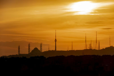 Silhouette of buildings against cloudy sky during sunset