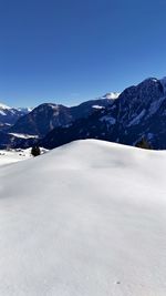 Scenic view of snowcapped mountains against clear blue sky