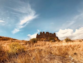 Old ruin on field against sky