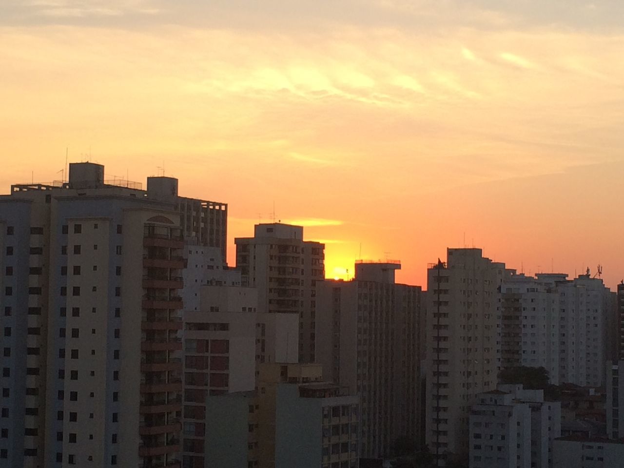 MODERN BUILDINGS IN CITY AGAINST SKY DURING SUNSET