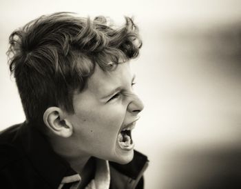 Close-up of angry boy shouting outdoors