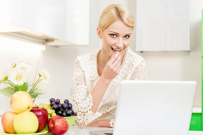 Potrait of woman eating in kitchen
