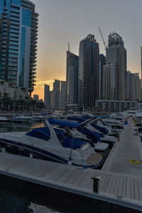 Modern buildings in city against sky during sunset