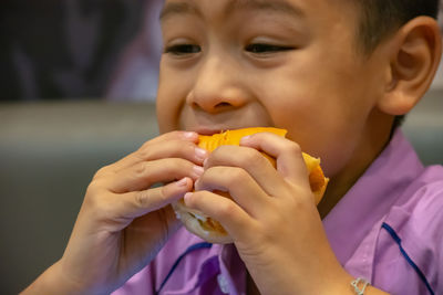 Close-up of boy eating burger