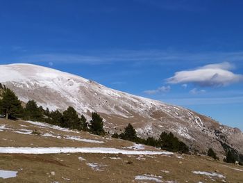 Scenic view of snowcapped mountains against blue sky