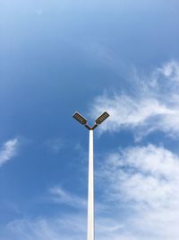 Low angle view of street light against blue sky