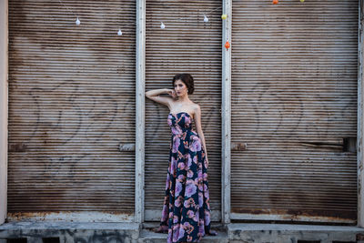 Portrait of woman standing against brick wall