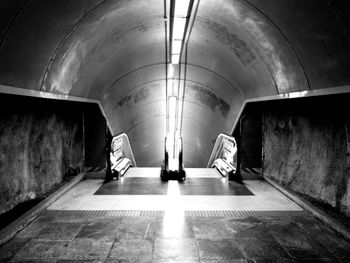 Escalator in illuminated subway tunnel