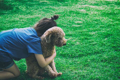 Rear view of girls with dog on field