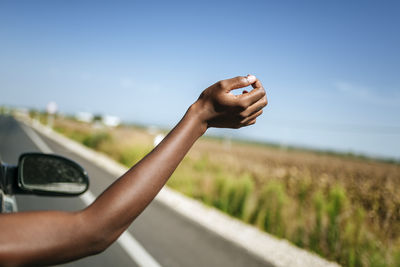 Hand of a woman leaning out of car window