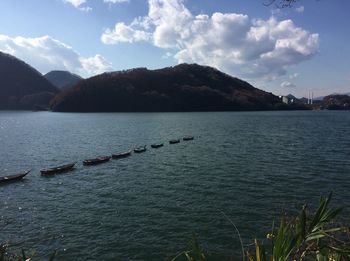 Scenic view of lake by mountains against sky