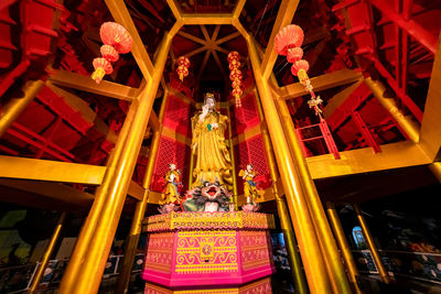 Low angle view of statue against illuminated building