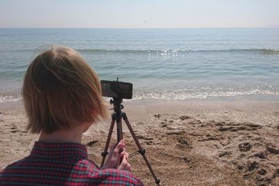 Woman photographing sea