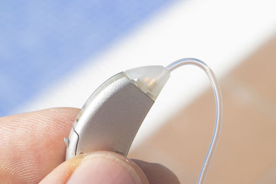 Cropped hand holding hearing aid
