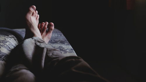 Low section of man relaxing on bed