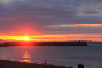 Scenic view of sea against orange sky