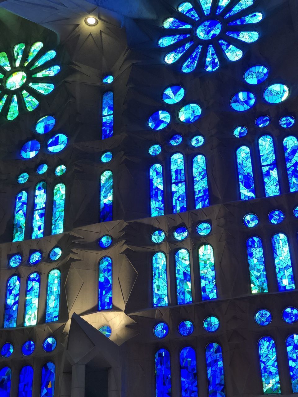 LOW ANGLE VIEW OF ILLUMINATED GLASS WINDOW IN TEMPLE