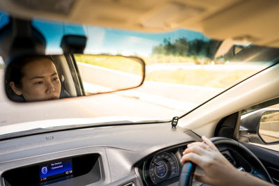 Reflection of woman in car mirror