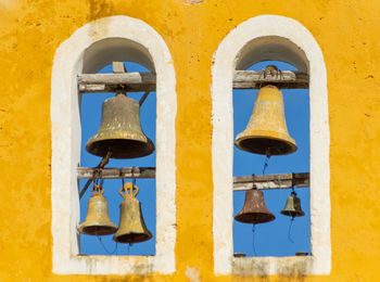 Close-up of metal hanging against yellow wall