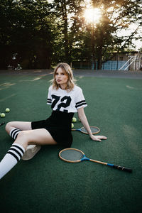 Portrait of young woman sitting on court