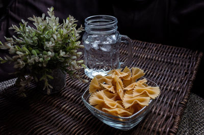 Farfalle pasta and drinking water on wicker mat