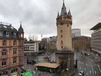 Buildings in city against cloudy sky