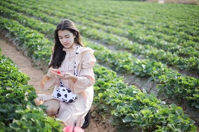 Young woman holding ice cream in farm