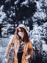 Woman wearing hat standing against snow during winter