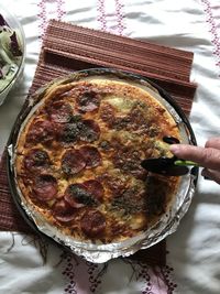 High angle view of hand holding pizza