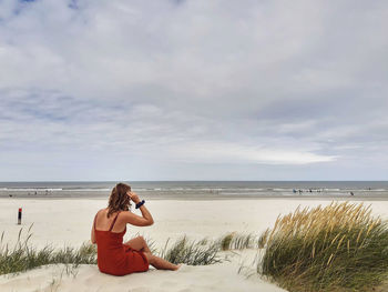 Beach girl sitting in sand dunes