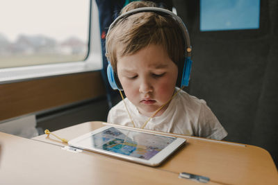 Boy in train using tablet