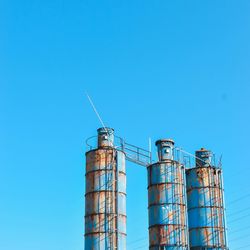 Low angle view of smoke stack against blue sky